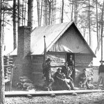 Officers quarters, showing common winter lodgings of log walls and fireplace with tent for roof.